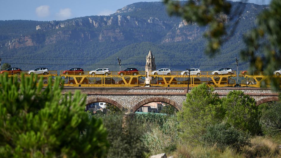 Tren portacoches cruzando un puente 