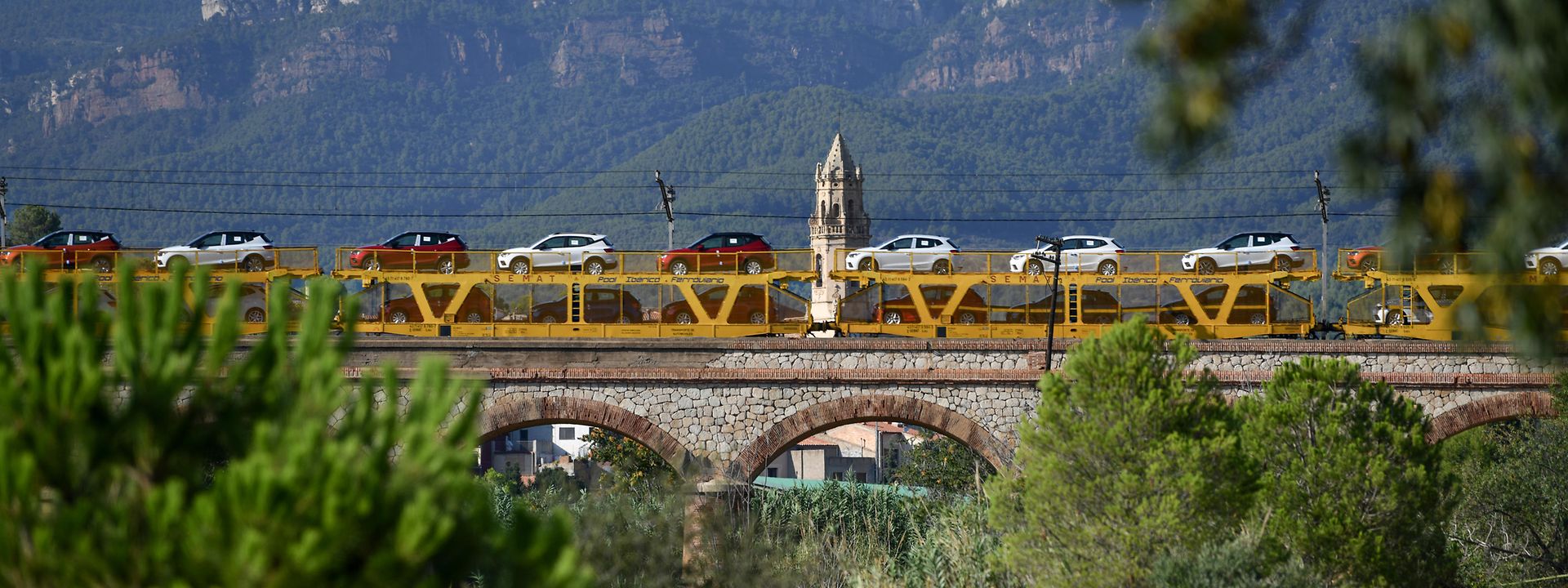 Tren portacoches cruzando un puente 