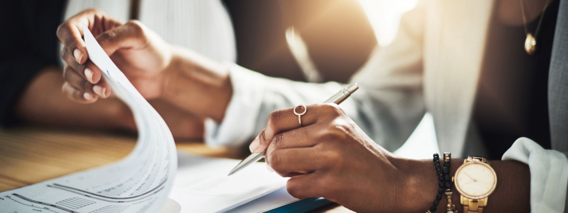 Two people sign a document. 