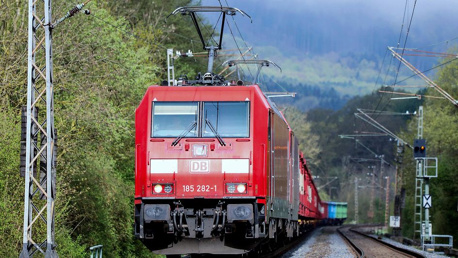 Freight train with green mountainous landscape 