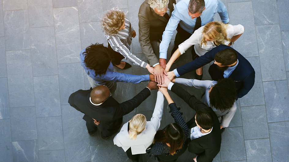Group of people joining hands 